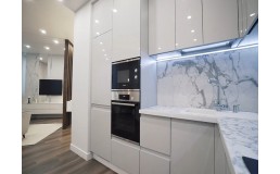 Белая кухня с крашеными фасадами и проходной ручкой. Фурнитура Blum и Hettich